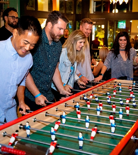 group of friends playing foosball