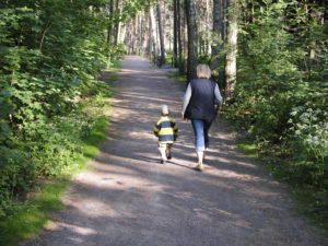 grandmother and child walking along trail