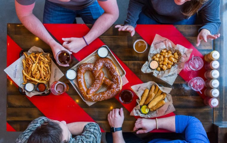 people dining on appetizers, including a giant pretzel