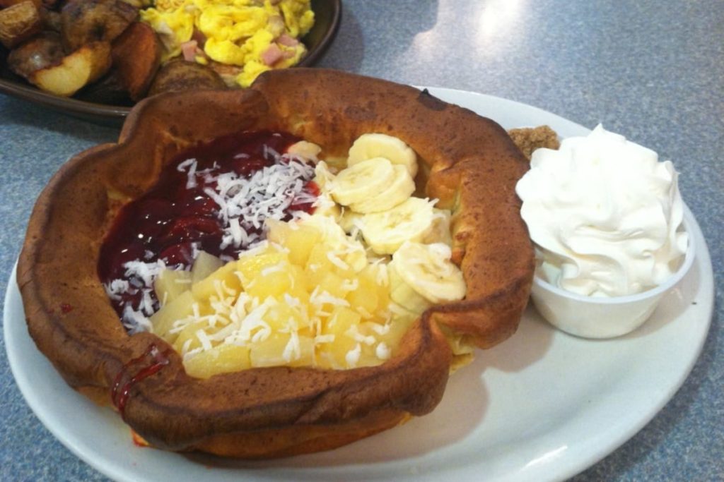 traditional pannekoeken with bananas, pineapple and berry toppings