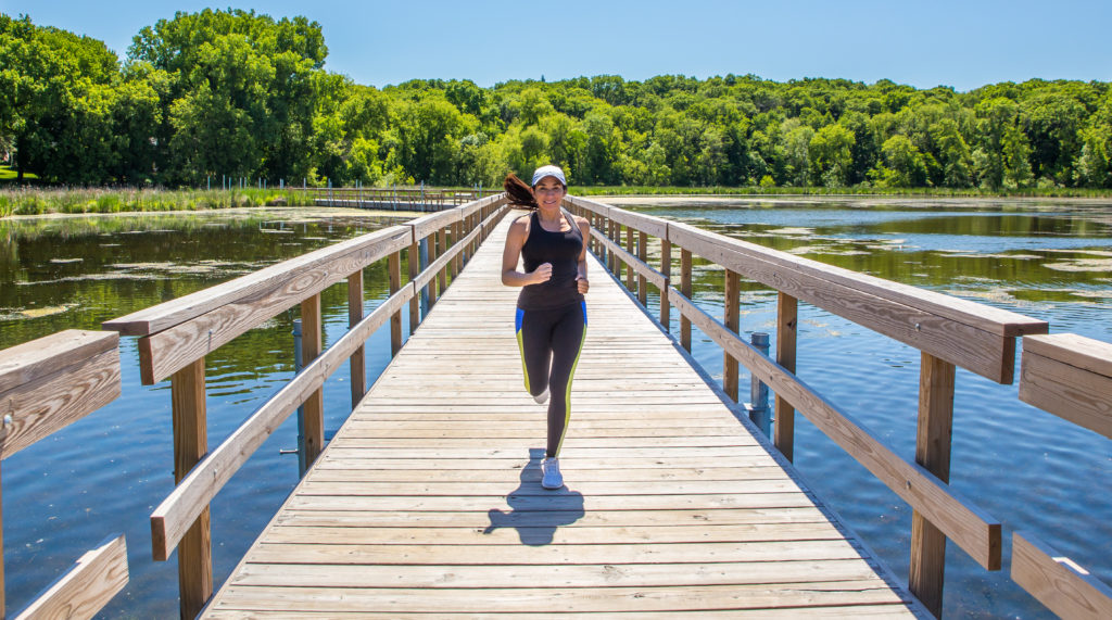 woman running on floating boardwalk at nature center