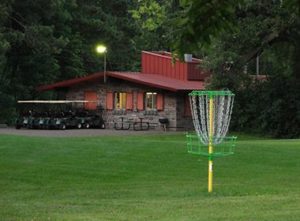 disc golf tee with clubhouse in the background