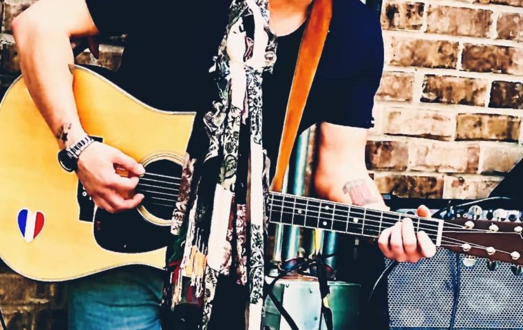 cropped image of Tim Mahoney playing guitar
