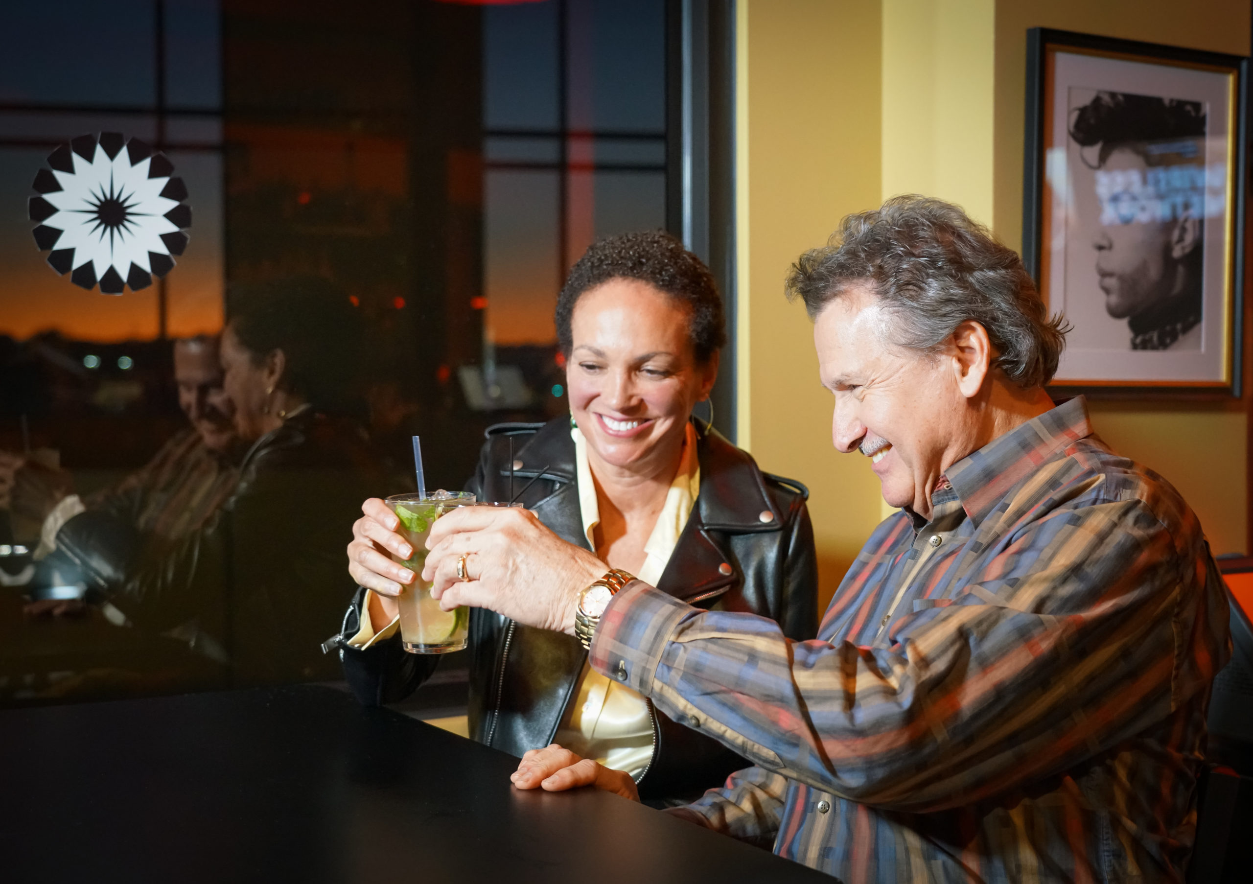 couple holding cocktails toasting one another