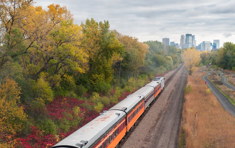 train alongside of bike trail with view of Minneapolis in the distance on a fall day