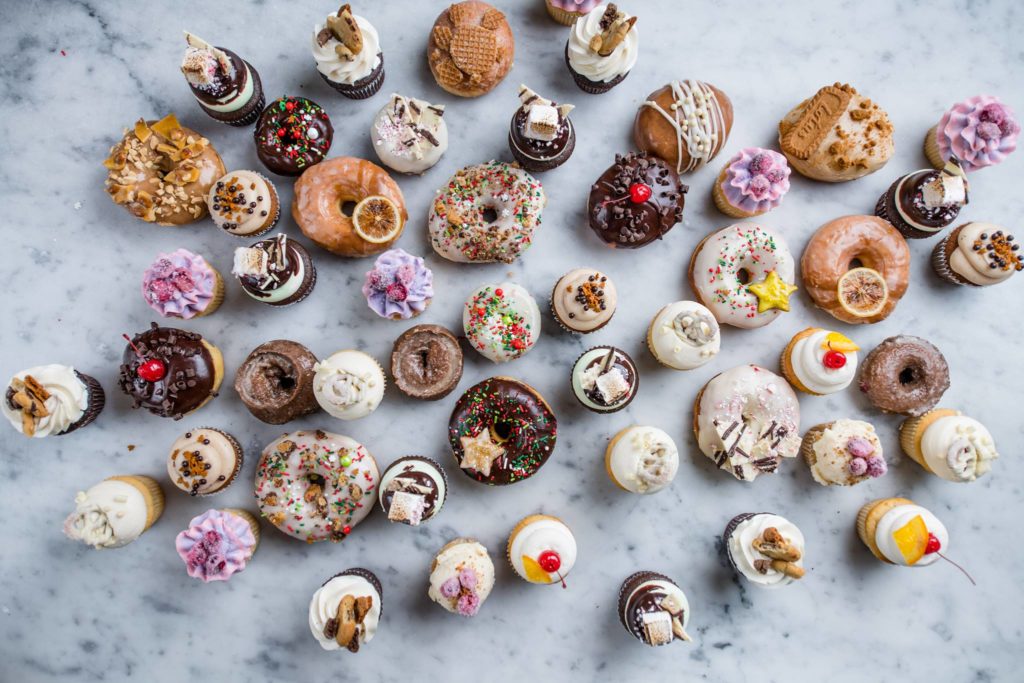 an array of donuts and cupcakes