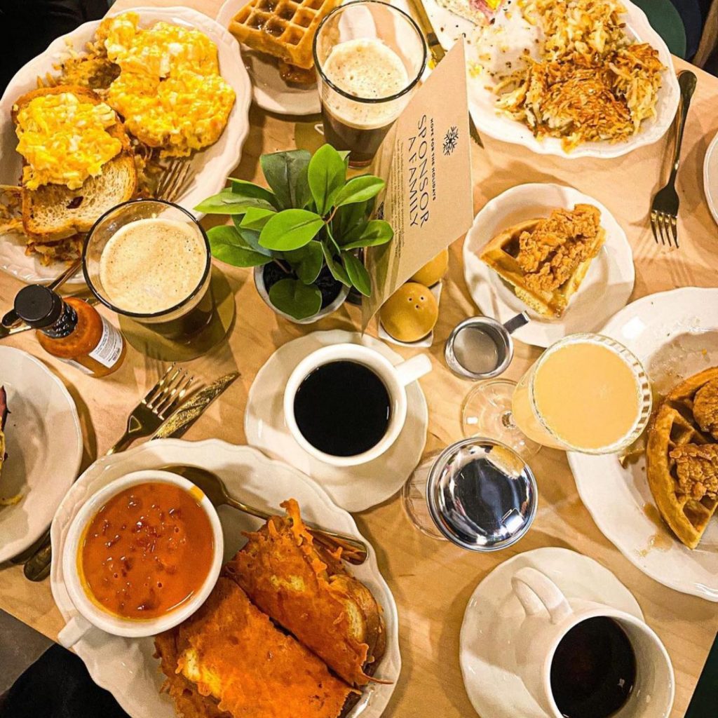 table loaded with breakfast foods and beverages
