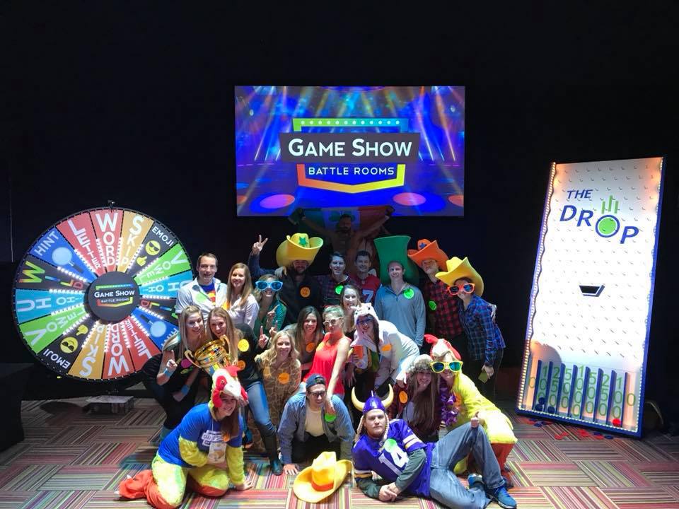 a group of winning players posing for the camera at Game Show Battle Rooms