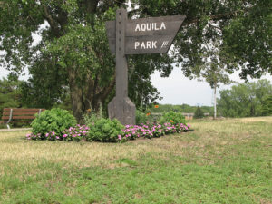 a wooden sign at the entrance to Aquila Park