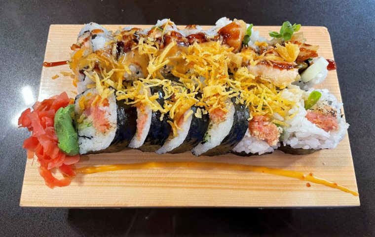 2 different types of sushi at Sato Sushi displayed on a wood board