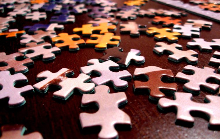 Jigsaw puzzles spread out on a table at Puzzlepalooza