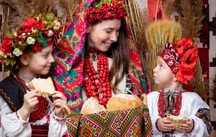 A family in traditional Slavic garb eating bread