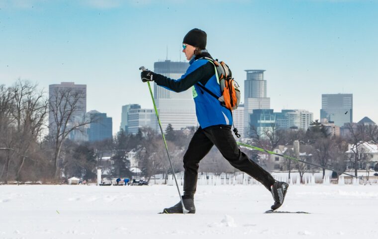 A person cross country skiing with a view of downtown Minneapolis in the background