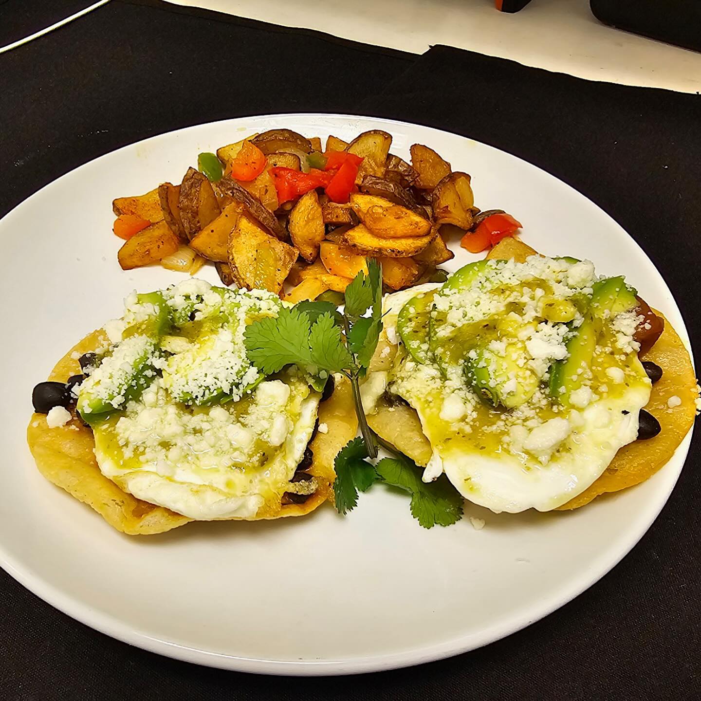 Breakfast eggs on corn tortillas with avocado and tomatillo sauce